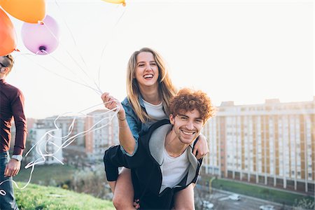 simsearch:649-08949687,k - Friends enjoying roof party, Young man giving young woman piggyback Stock Photo - Premium Royalty-Free, Code: 649-08949683