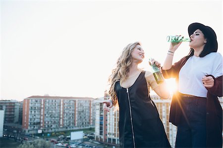simsearch:649-08949687,k - Two young women, on roof top, drinking bottled beer Stock Photo - Premium Royalty-Free, Code: 649-08949691
