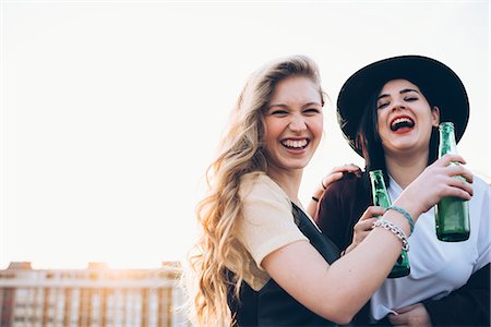 simsearch:649-08949687,k - Two young women, outdoors, drinking bottled beer, laughing Stock Photo - Premium Royalty-Free, Code: 649-08949693