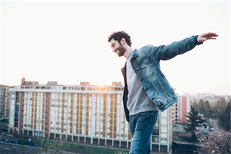 simsearch:649-08949684,k - Young man walking on rooftop, smiling Stockbilder - Premium RF Lizenzfrei, Bildnummer: 649-08949700