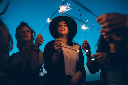simsearch:649-08949687,k - Group of friends enjoying roof party, holding lit sparklers Stock Photo - Premium Royalty-Free, Code: 649-08949715