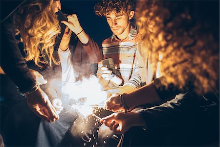 simsearch:649-08949675,k - Group of friends enjoying roof party, lighting sparklers Foto de stock - Sin royalties Premium, Código: 649-08949716