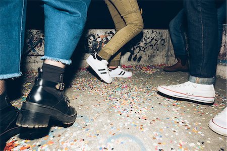 Group of friends, standing outdoors, confetti on floor, low section Stock Photo - Premium Royalty-Free, Code: 649-08949710