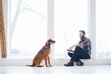 spacious - Young male designer with dog in design studio window seat Stock Photo - Premium Royalty-Free, Code: 649-08949783