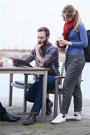 Male and female design team looking at digital tablet on waterfront outside design studio Stock Photo - Premium Royalty-Free, Code: 649-08949791
