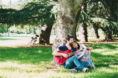 Couple sitting in park playing guitar, Arezzo, Tuscany, Italy Stock Photo - Premium Royalty-Free, Code: 649-08949874