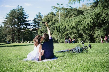 simsearch:649-08949872,k - Rear view of couple taking smartphone selfie while sitting in park, Arezzo, Tuscany, Italy Stock Photo - Premium Royalty-Free, Code: 649-08949876