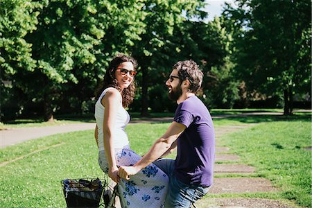 simsearch:649-08949872,k - Young woman on handlebars of boyfriend's bicycle in park, Arezzo, Tuscany, Italy Stock Photo - Premium Royalty-Free, Code: 649-08949873