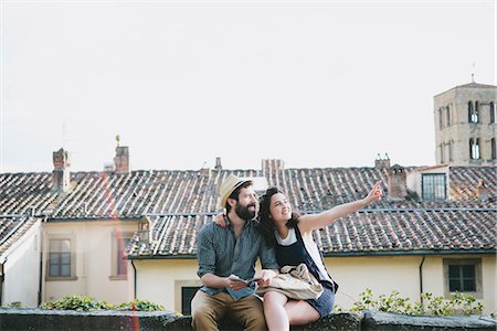 simsearch:649-08949872,k - Couple sitting on wall pointing, Arezzo, Tuscany, Italy Stock Photo - Premium Royalty-Free, Code: 649-08949881
