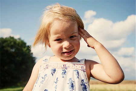 Portrait of female toddler in field with hand in blond hair Stock Photo - Premium Royalty-Free, Code: 649-08949895