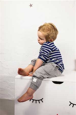 simsearch:649-07596283,k - Male toddler sitting gazing from toy chest Stock Photo - Premium Royalty-Free, Code: 649-08949967