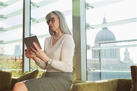 Businesswoman using digital tablet on office sofa. London, UK Stock Photo - Premium Royalty-Free, Code: 649-08950321