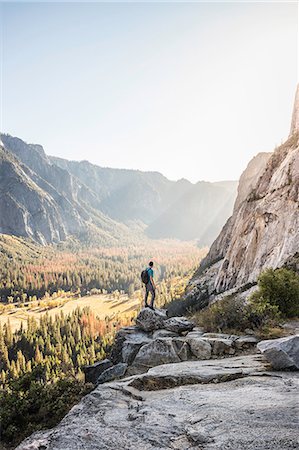 simsearch:6122-07703230,k - Man on boulder looking out at valley forest, Yosemite National Park, California, USA Stock Photo - Premium Royalty-Free, Code: 649-08950373