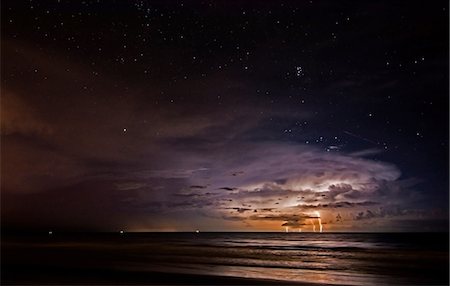 florida not tourism - As a lightning storm strikes the Atlantic Ocean off Cocoa Beach, Florida, a meteor streaks over the storm Stock Photo - Premium Royalty-Free, Code: 649-08950397