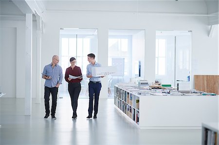 simsearch:649-08950473,k - Colleagues walking through open plan office Stock Photo - Premium Royalty-Free, Code: 649-08950470