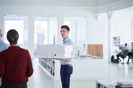 simsearch:649-08950473,k - Man in open plan office holding architectural model Stock Photo - Premium Royalty-Free, Code: 649-08950472