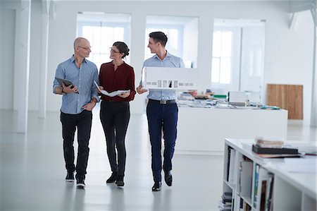 simsearch:649-08824281,k - Colleagues walking through open plan office Stock Photo - Premium Royalty-Free, Code: 649-08950473