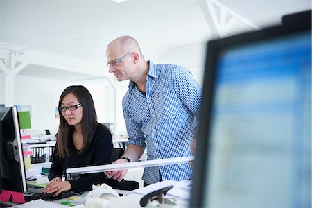 diseñador (hombre y mujer) - Colleagues working in office, using computer Foto de stock - Sin royalties Premium, Código: 649-08950501