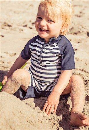 simsearch:649-08745640,k - Portrait of young boy, sitting on beach, smiling Stock Photo - Premium Royalty-Free, Code: 649-08950520