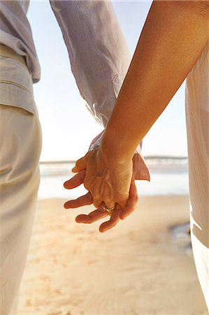 simsearch:649-08901850,k - Mature couple at beach, holding hands, mid section, rear view Photographie de stock - Premium Libres de Droits, Code: 649-08950586