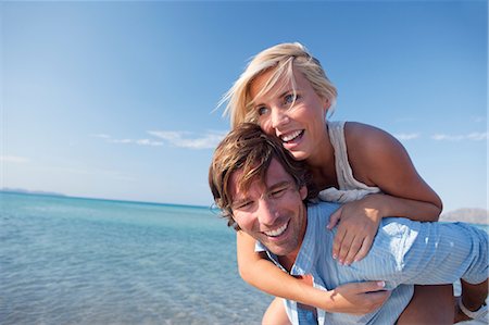 simsearch:649-06844748,k - Couple playing piggyback ride by sea Stock Photo - Premium Royalty-Free, Code: 649-08950640