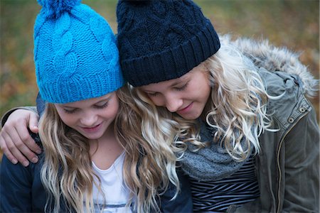 simsearch:649-08950750,k - Blond haired sisters wearing knit hats looking down in garden Stock Photo - Premium Royalty-Free, Code: 649-08950750