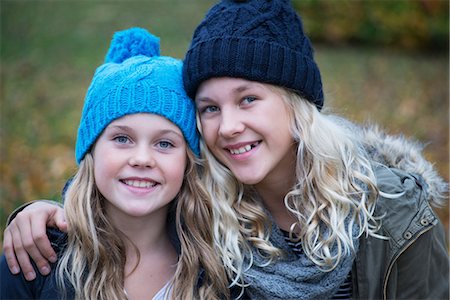 simsearch:649-08950750,k - Portrait of blond haired sisters wearing knit hats in garden Stock Photo - Premium Royalty-Free, Code: 649-08950751