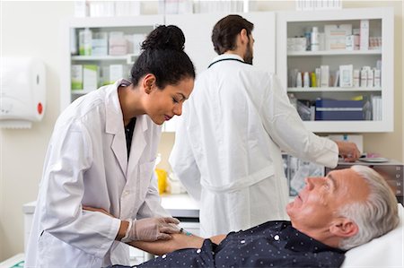 exames de sangue - Doctor extracting patient's blood with syringe Foto de stock - Royalty Free Premium, Número: 649-08950928