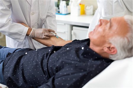 prise de sang - Doctor extracting patient's blood with syringe Photographie de stock - Premium Libres de Droits, Code: 649-08950929