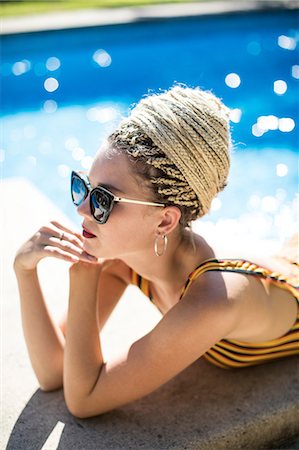 Young woman with dreadlocks, relaxing beside swimming pool Photographie de stock - Premium Libres de Droits, Code: 649-08950946