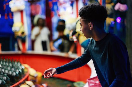 Young boy at funfair, playing on fairground stall Stock Photo - Premium Royalty-Free, Code: 649-08950969