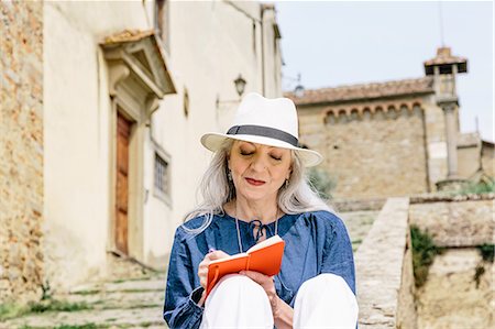 sombrero de jipijapa - Stylish mature woman writing in notebook outside church, Fiesole, Tuscany, Italy Foto de stock - Sin royalties Premium, Código: 649-08951139