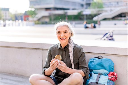 Portrait of mature female backpacker with sandwich in bus station, Scandicci, Tuscany, Italy Photographie de stock - Premium Libres de Droits, Code: 649-08951153