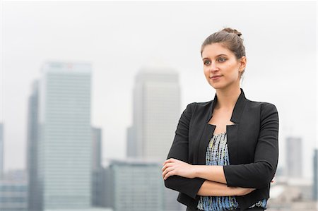 simsearch:649-08950729,k - Confident young businesswoman with arms crossed on city office roof terrace, London, UK Stock Photo - Premium Royalty-Free, Code: 649-08968857