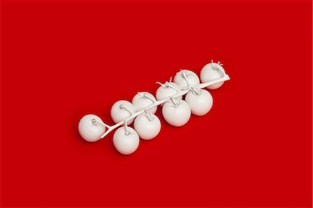 still life odd - Tomatoes on the vine painted white on red background Stock Photo - Premium Royalty-Free, Code: 649-08968882