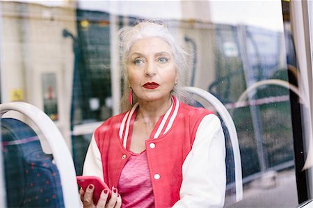 Mature woman in baseball jacket looking through window from bus Stockbilder - Premium RF Lizenzfrei, Bildnummer: 649-08969124
