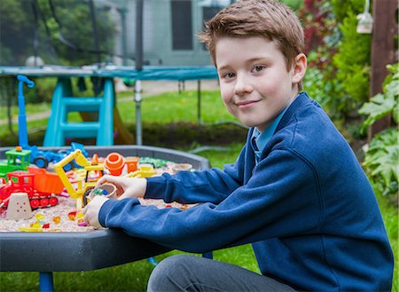 simsearch:614-09056681,k - Portrait of boy playing in sandpit looking at camera smiling Fotografie stock - Premium Royalty-Free, Codice: 649-08969187