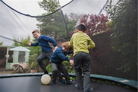 simsearch:649-07119796,k - Boys on trampoline playing football Photographie de stock - Premium Libres de Droits, Code: 649-08969182
