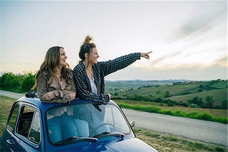 person standing on the sunroof - Tourists standing through car sunroof, countryside, Tuscany, Italy Stock Photo - Premium Royalty-Free, Code: 649-08969255