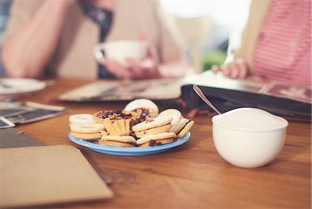 simsearch:649-08328527,k - Cropped shot of senior women at table with sugar bowl, biscuits and photo album Stock Photo - Premium Royalty-Free, Code: 649-08969522