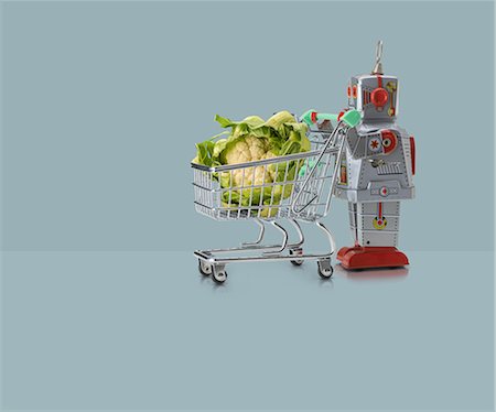 simsearch:649-08423033,k - Toy robot pushing miniature shopping trolley with cauliflower against blue background Stock Photo - Premium Royalty-Free, Code: 649-08969531