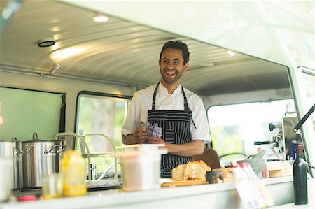 Small business owner preparing food in van food stall Stock Photo - Premium Royalty-Free, Code: 649-08969555