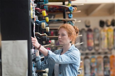 simsearch:614-08641283,k - Woman working in skateboard shop, putting skateboard on shelf Photographie de stock - Premium Libres de Droits, Code: 649-08969562