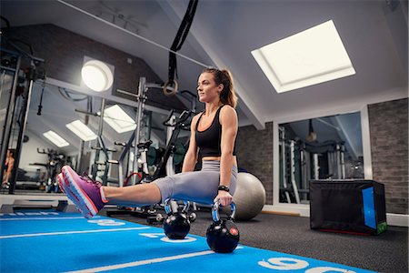 simsearch:614-09026692,k - Young woman training, doing sit up push ups on kettle bells in gym Stock Photo - Premium Royalty-Free, Code: 649-08969578