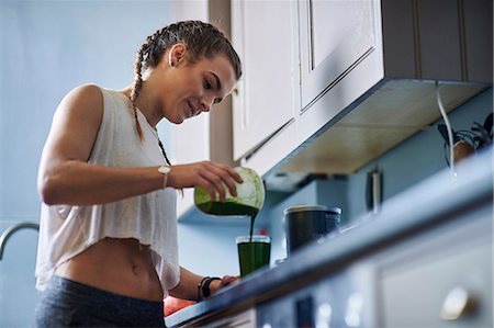 fitness home - Young woman pouring smoothie at kitchen counter Foto de stock - Sin royalties Premium, Código: 649-08969594