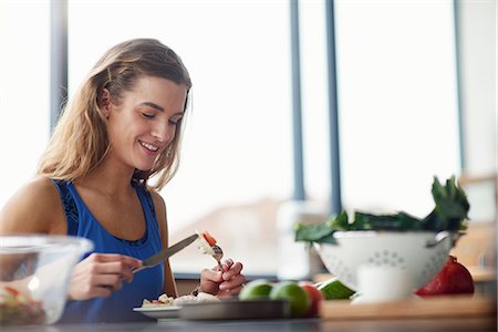 simsearch:649-07559812,k - Young woman at kitchen table eating feta salad Stock Photo - Premium Royalty-Free, Code: 649-08969607