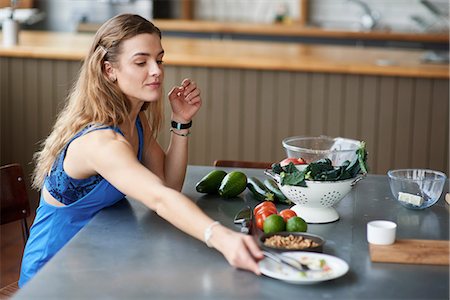 simsearch:649-07559812,k - Young woman at kitchen table with finished salad plate Stock Photo - Premium Royalty-Free, Code: 649-08969609