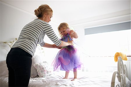 simsearch:649-01621440,k - Young girl dressed in fairy costume, standing on bed, mother lifting her Stock Photo - Premium Royalty-Free, Code: 649-08969834