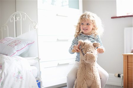 Little girl on rocking horse in bedroom Photographie de stock - Premium Libres de Droits, Code: 649-08969861