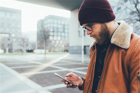 simsearch:649-08969957,k - Young male hipster in city looking at smartphone Stock Photo - Premium Royalty-Free, Code: 649-08969956